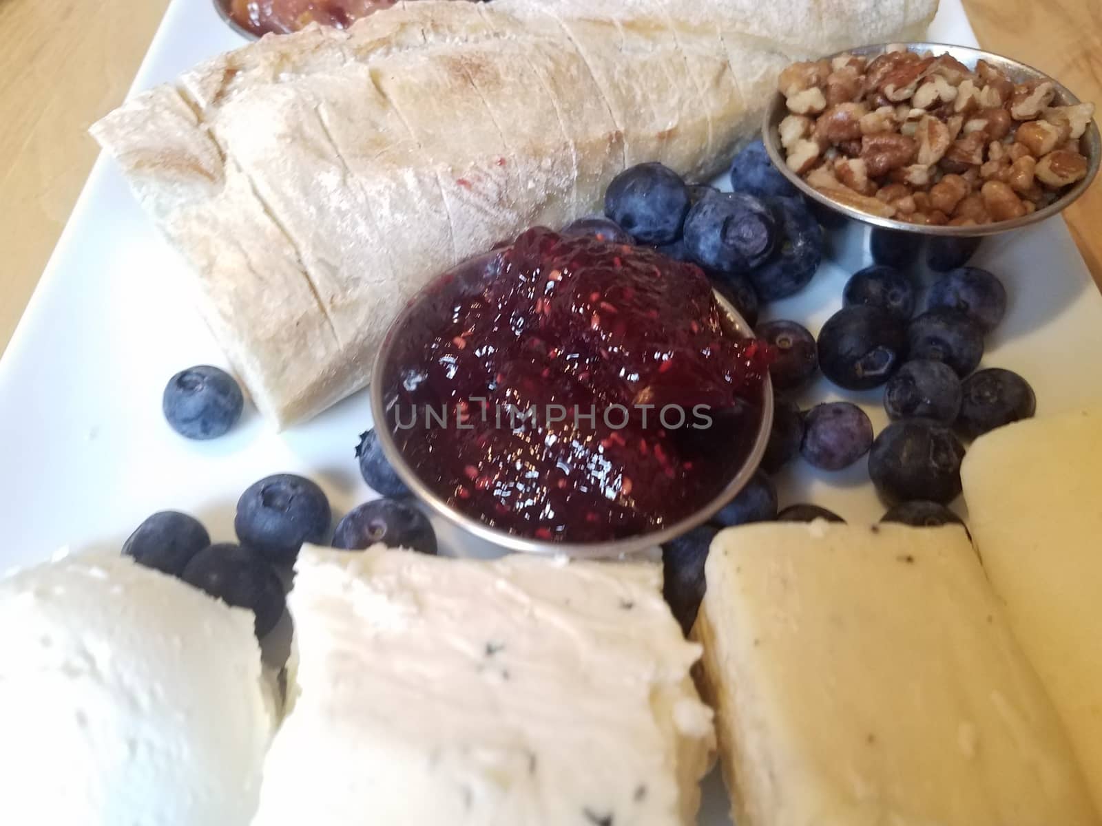 cheese and pecans and bread and blueberries on white plate by stockphotofan1