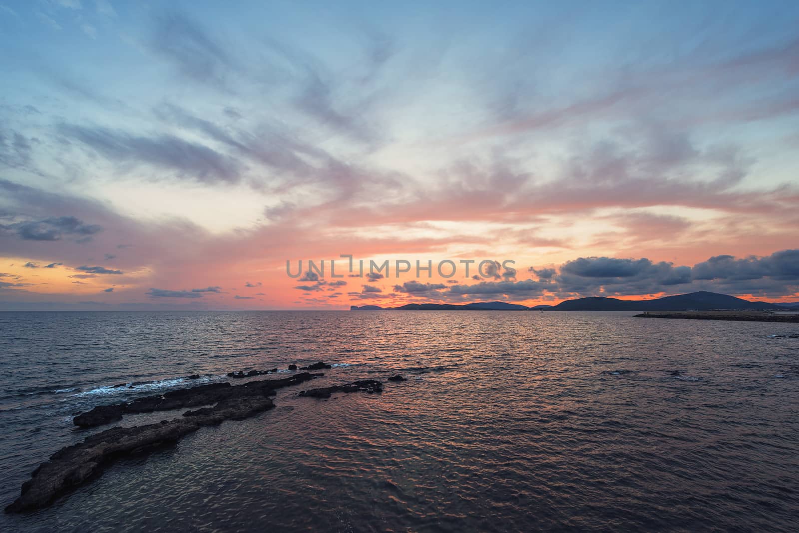 amazing colorful sunset in the Gulf of Alghero, Sardinia, Italy
