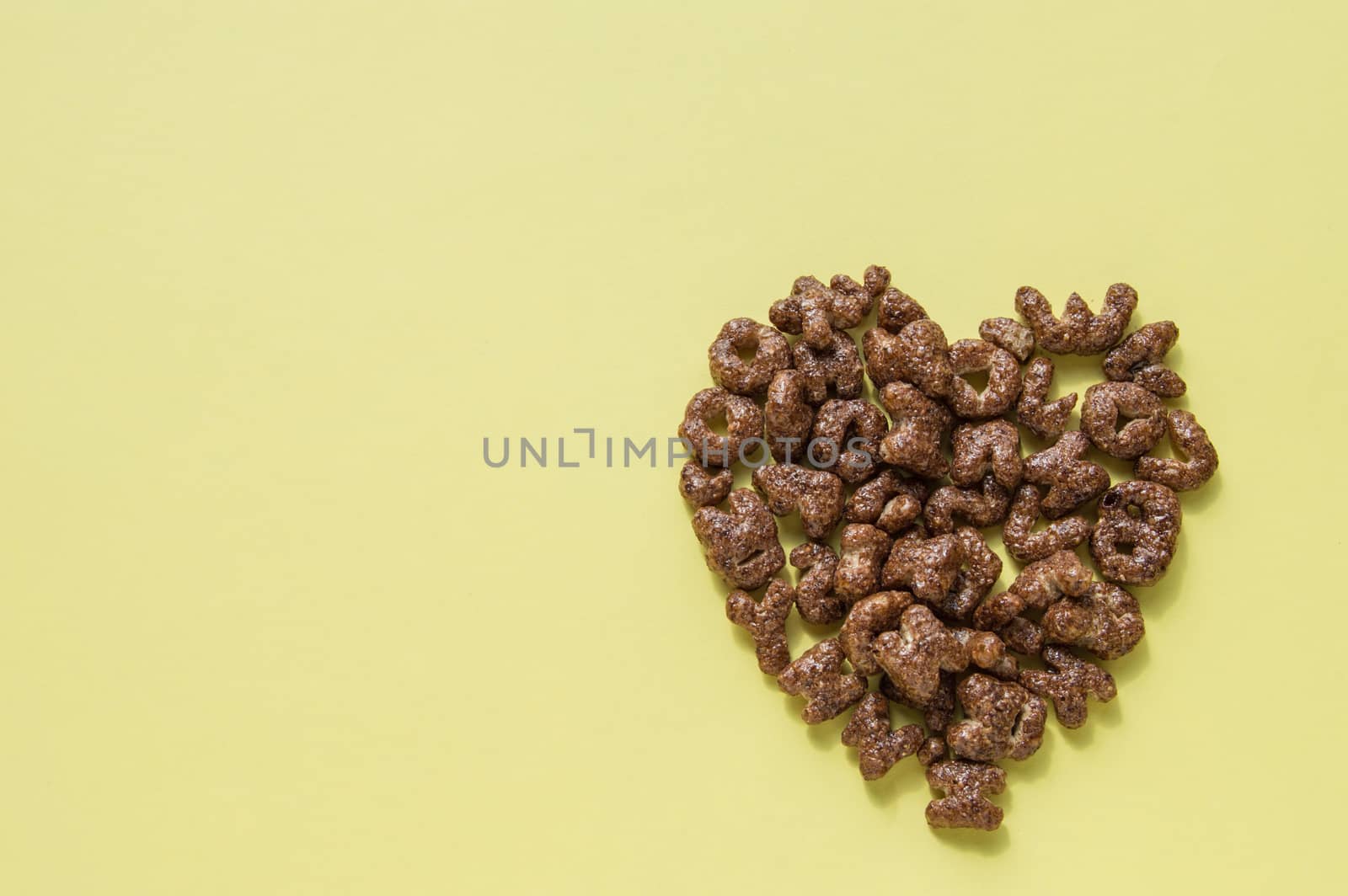 Sign of the heart of the dry Breakfast cereal in the form of letters of the alphabet, chocolate flakes useful food for children, the top view copy space, flat lay.