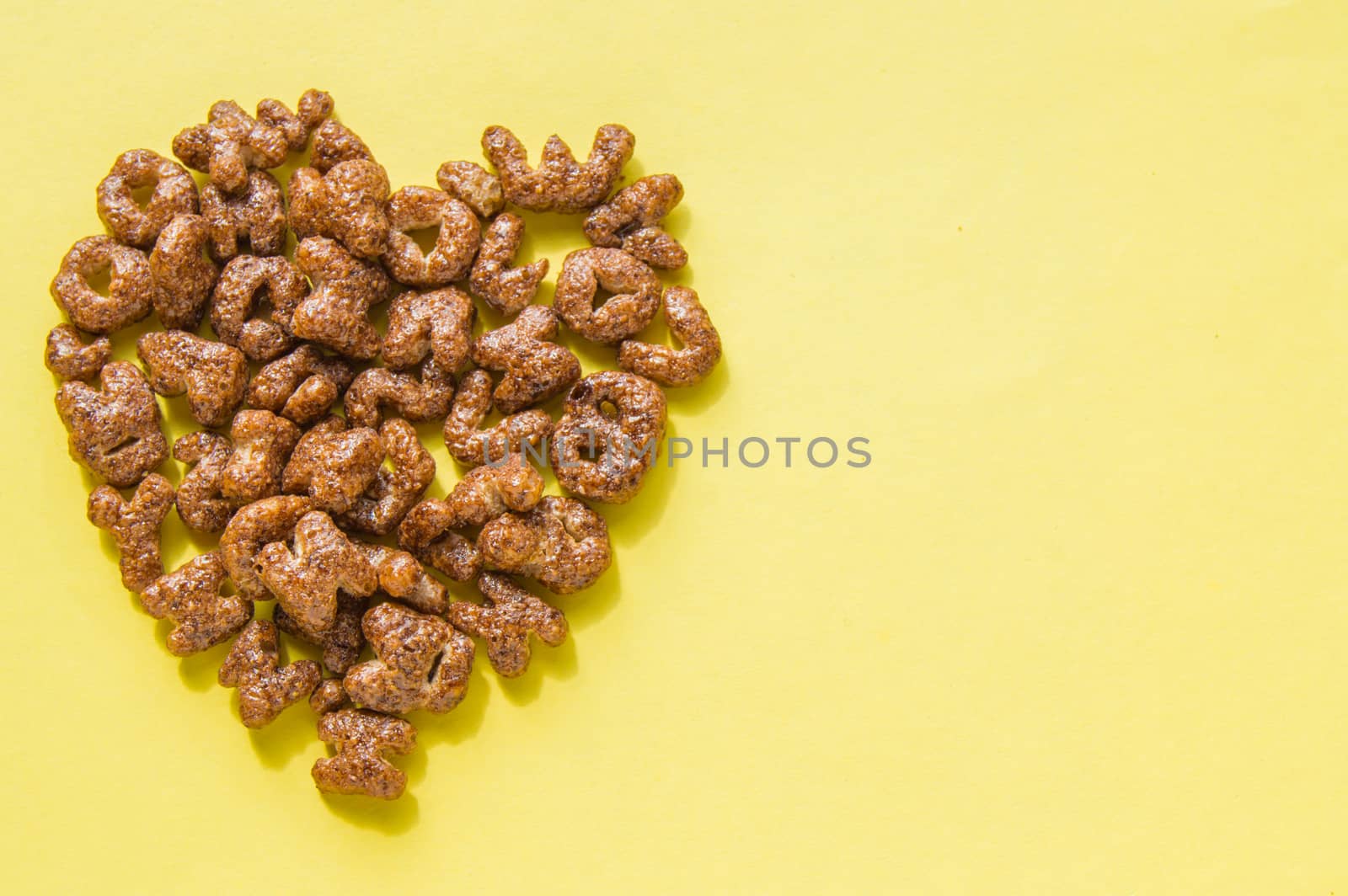 Sign of the heart of the dry Breakfast cereal in the form of letters of the alphabet, chocolate flakes useful food for children, the top view copy space, flat lay.