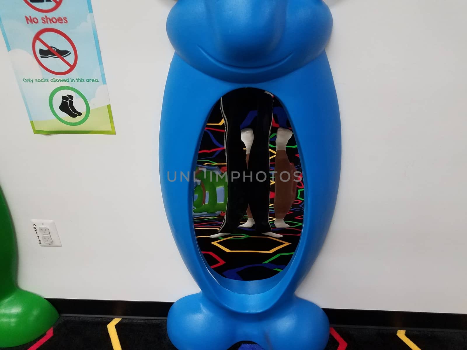 father and son distorted in reflection in blue funhouse mirror