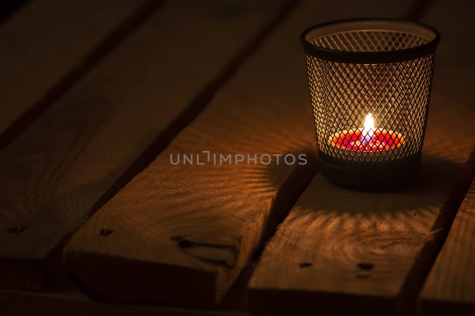 Candle light on natural wooden background. Tealight.  Soft focus.