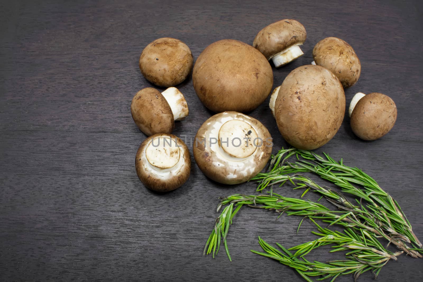Champignon Mushrooms and Rosemary on a Cutting Board