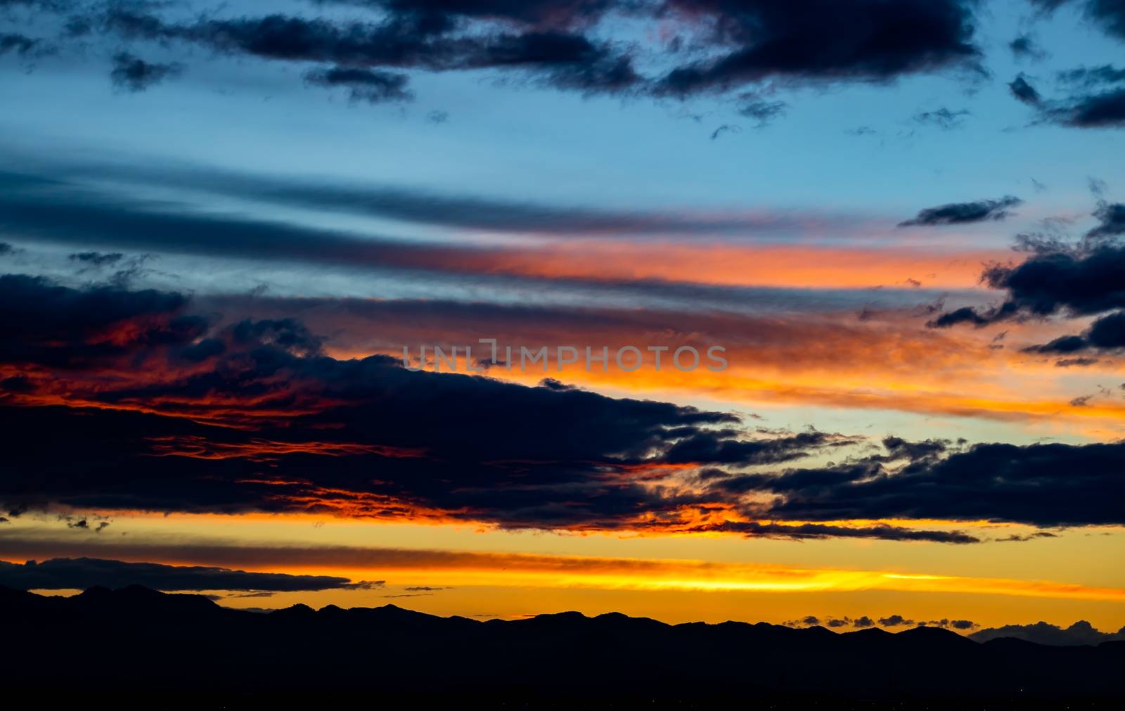 Sunset over mountains with storms clouds