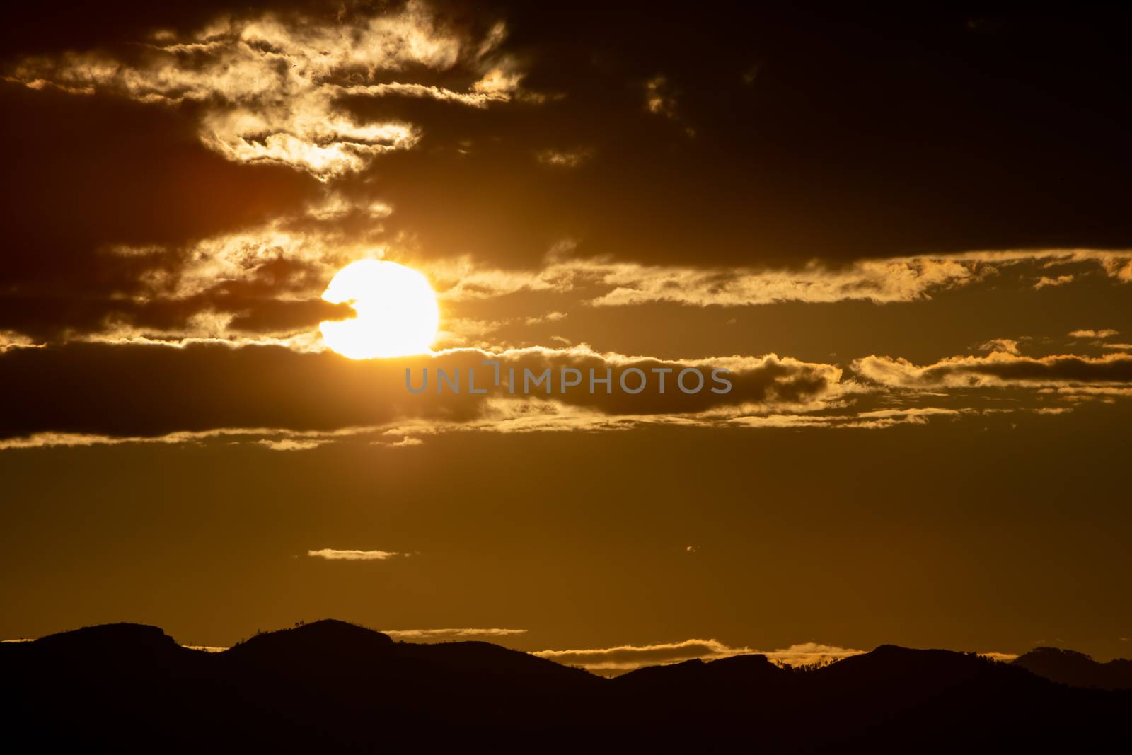 Sunset over mountains with storms clouds