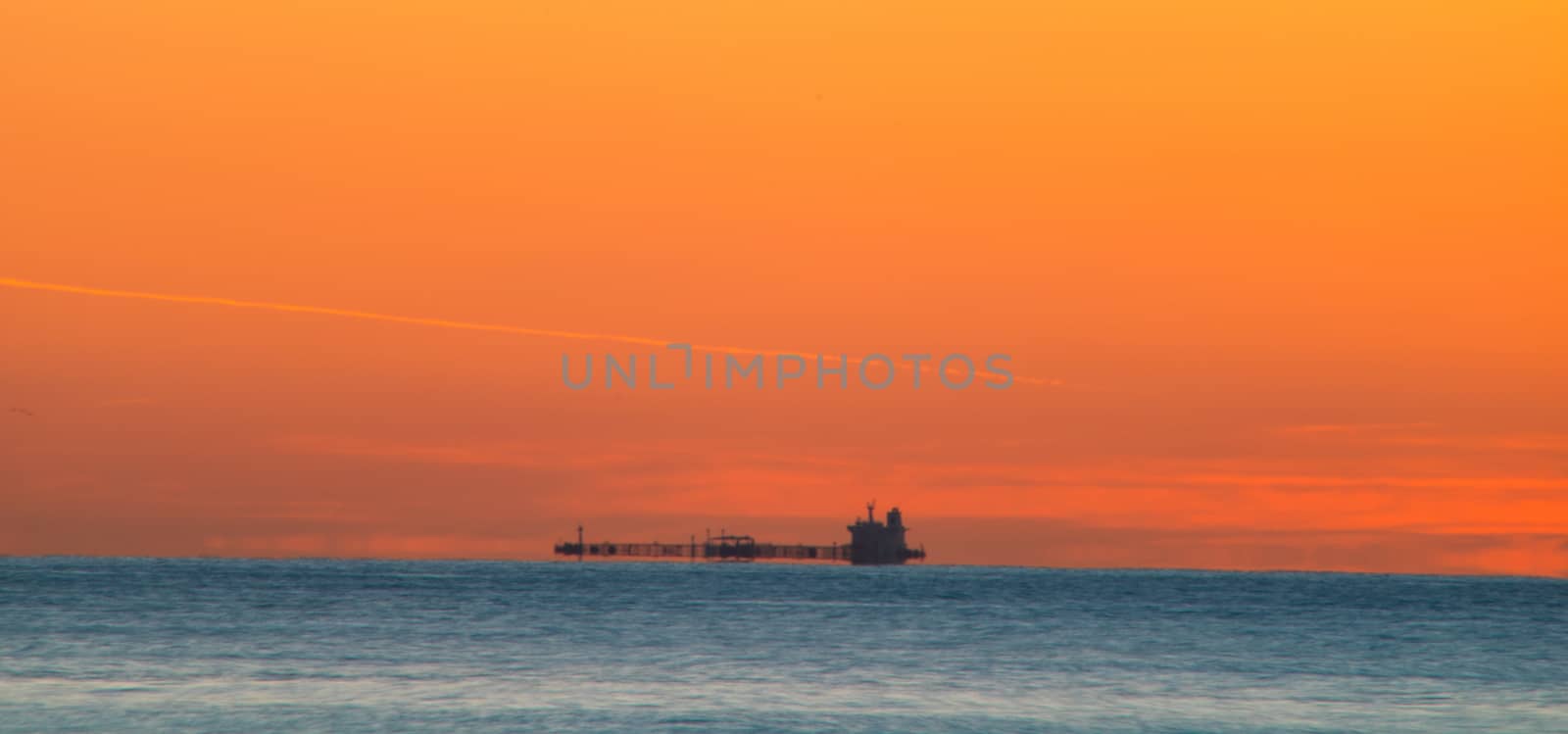 Freighter sailing at sunrise in the Mediterranean Sea