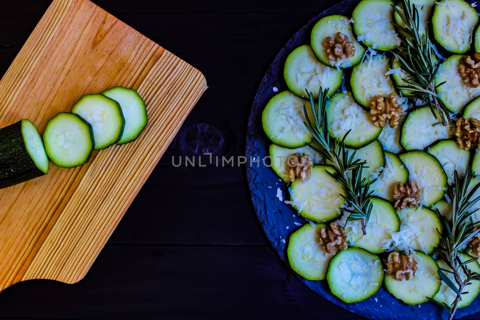 Carpaccio of zucchini with nuts and cheese on dark wooden background