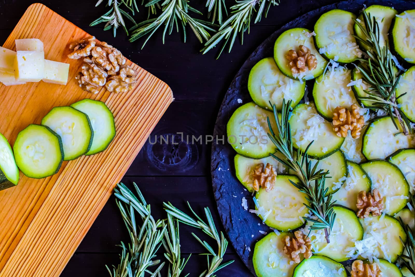 Carpaccio of zucchini with nuts and cheese on dark wooden background