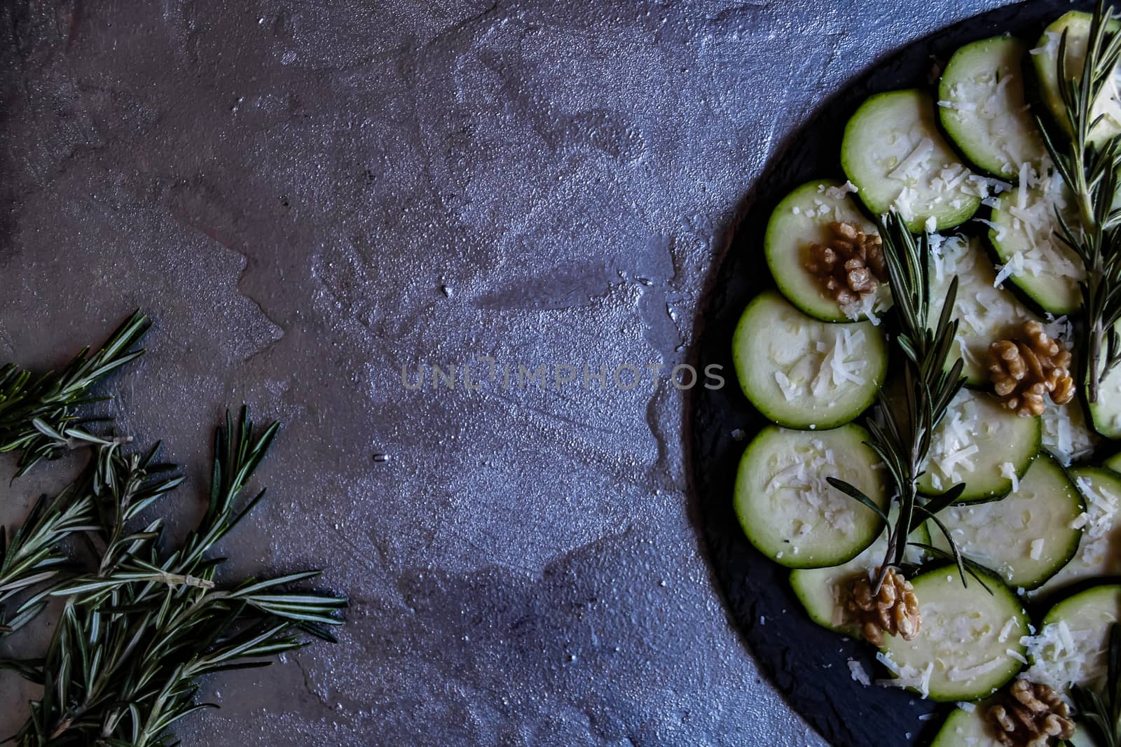 Carpaccio of zucchini with nuts and cheese on gray background