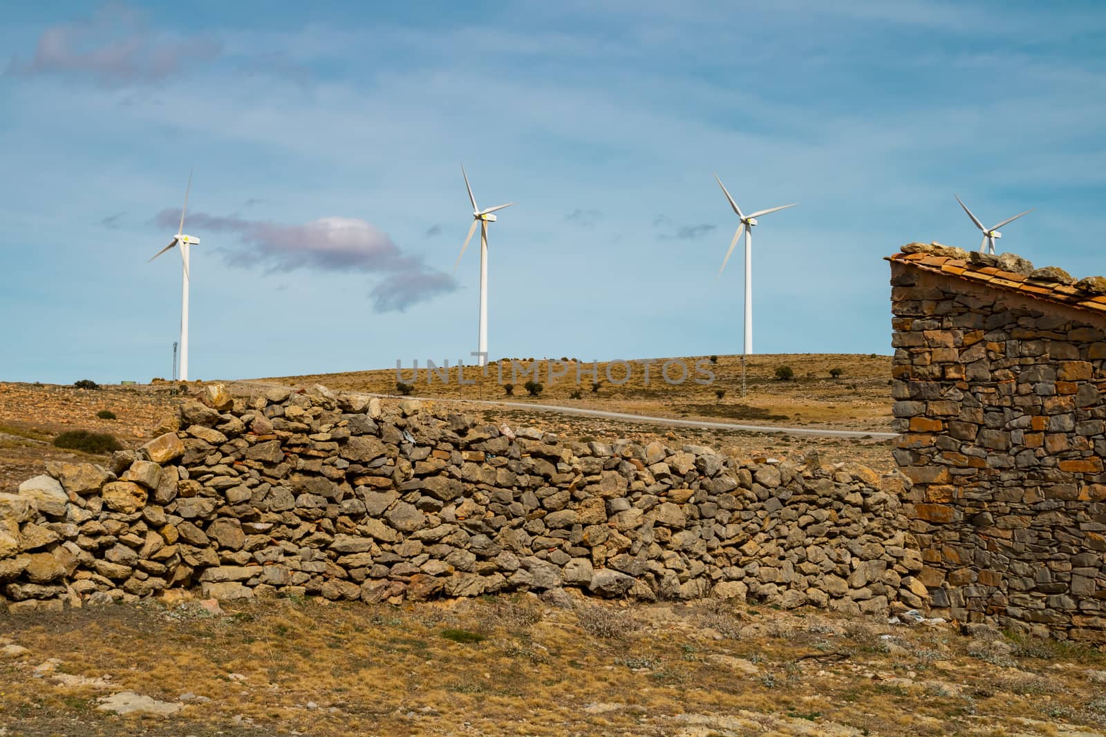 Old abandoned stone house with windmills in the background
