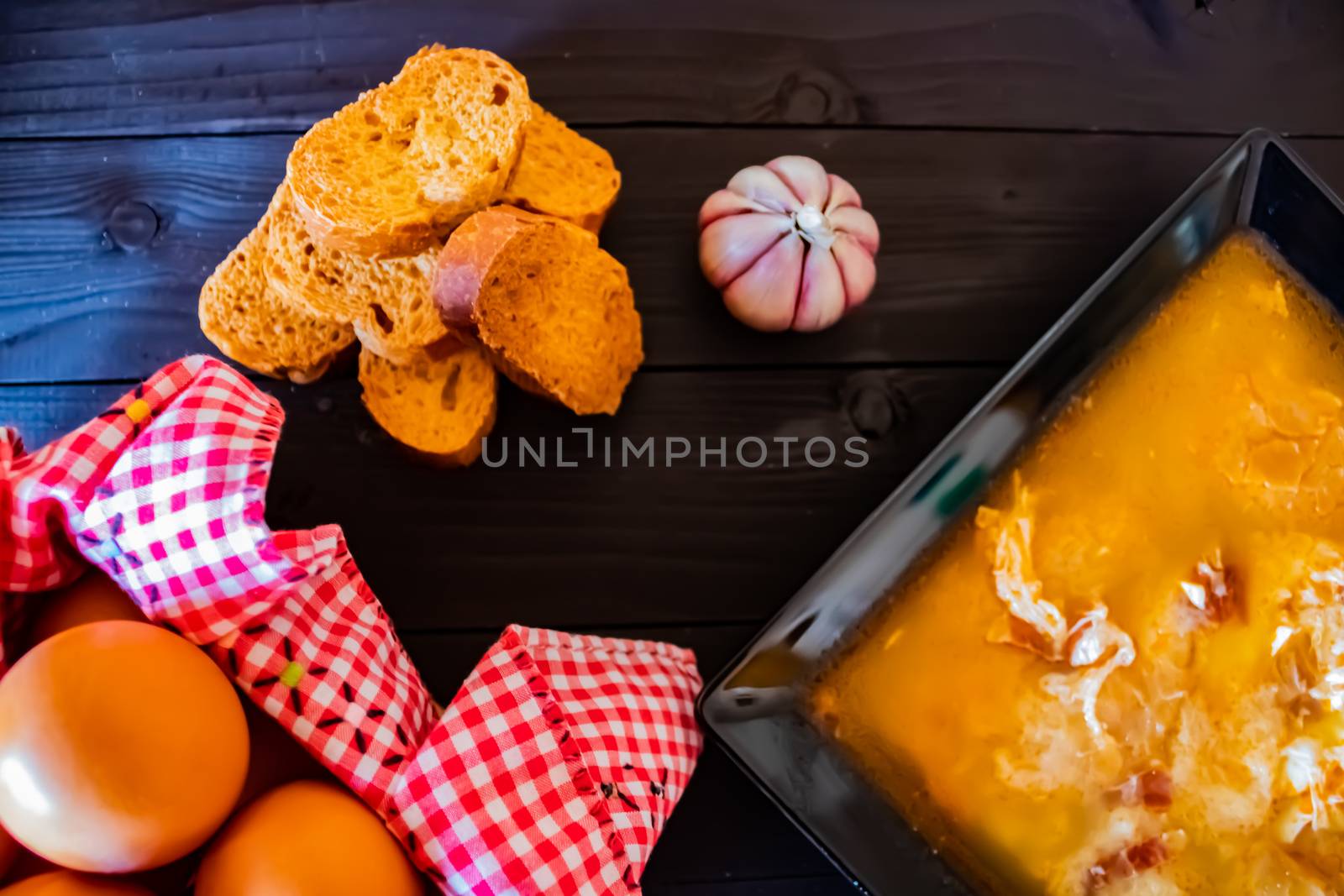 Typical Spanish garlic soups in composition on dark wood background