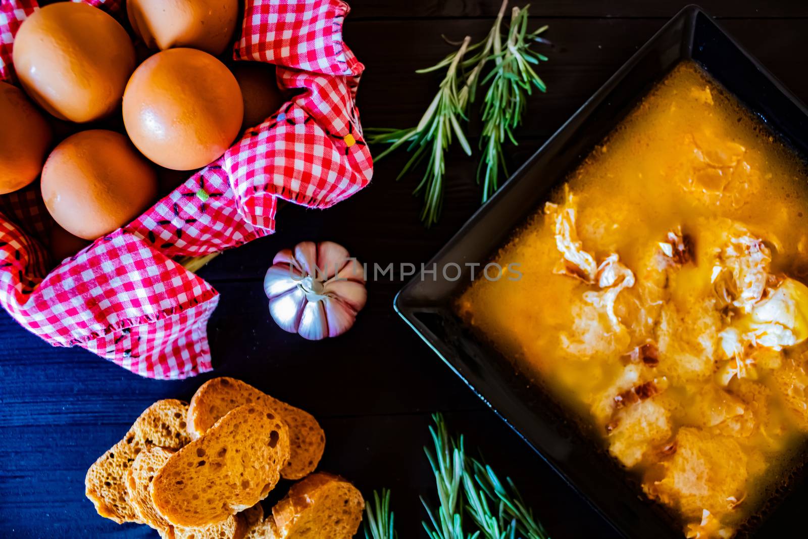 Typical Spanish garlic soups in composition on dark wood background
