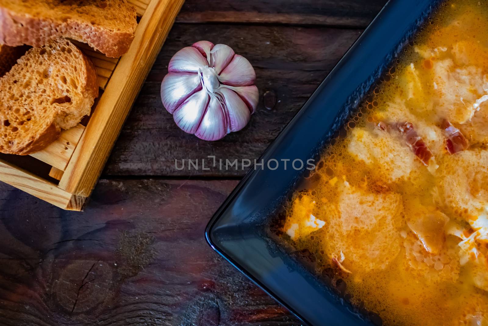 Typical Spanish garlic soups in composition on wood background