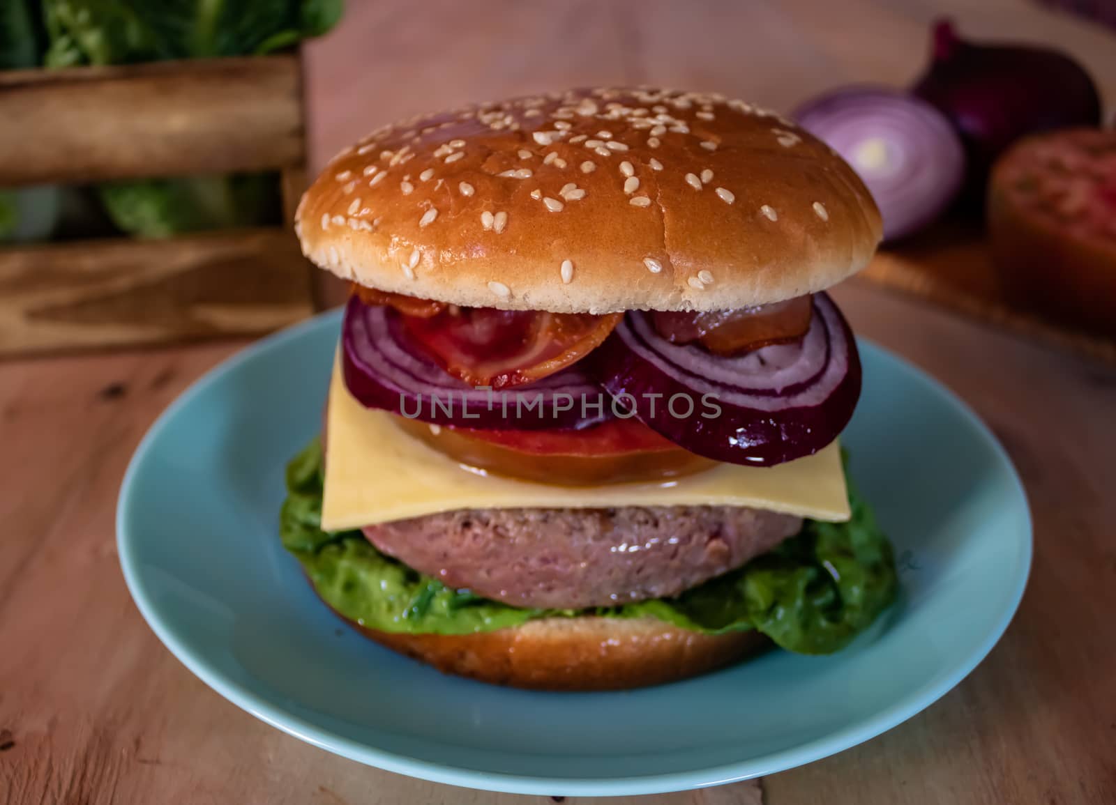 Hamburger and ingredients in composition on wooden background