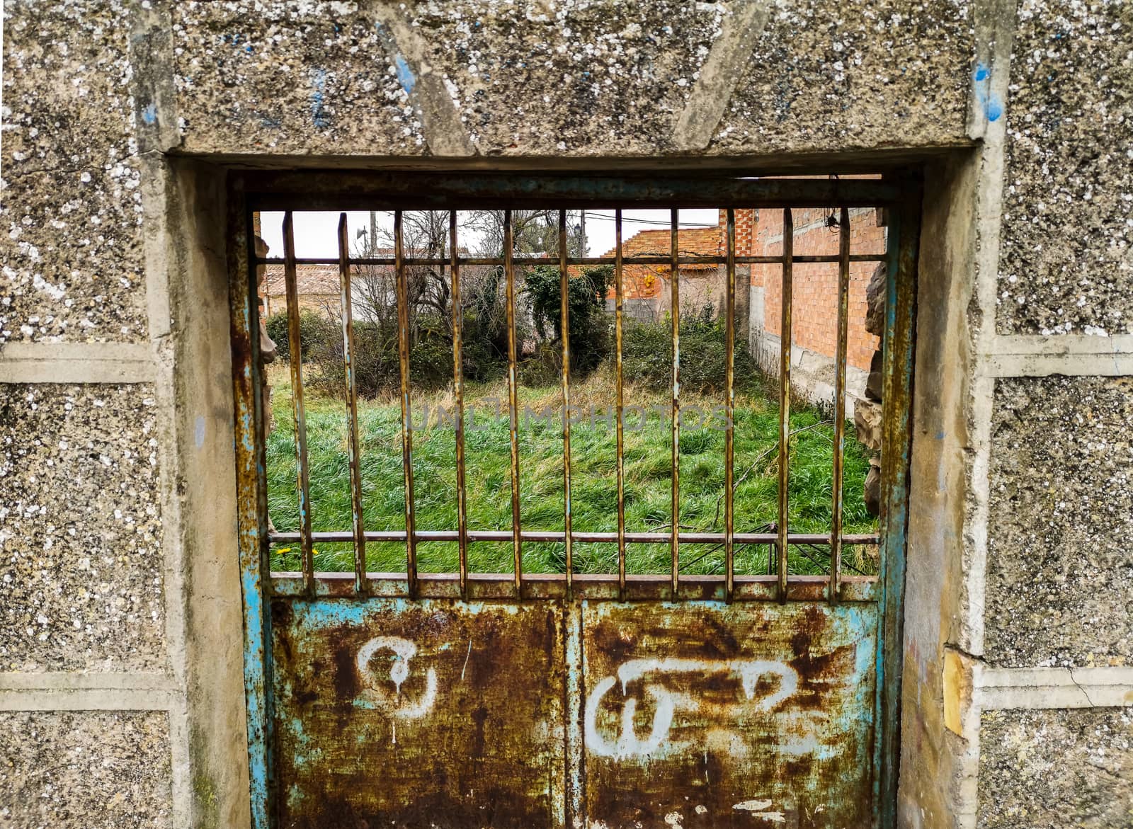 Old rusty metal door in a stone wall