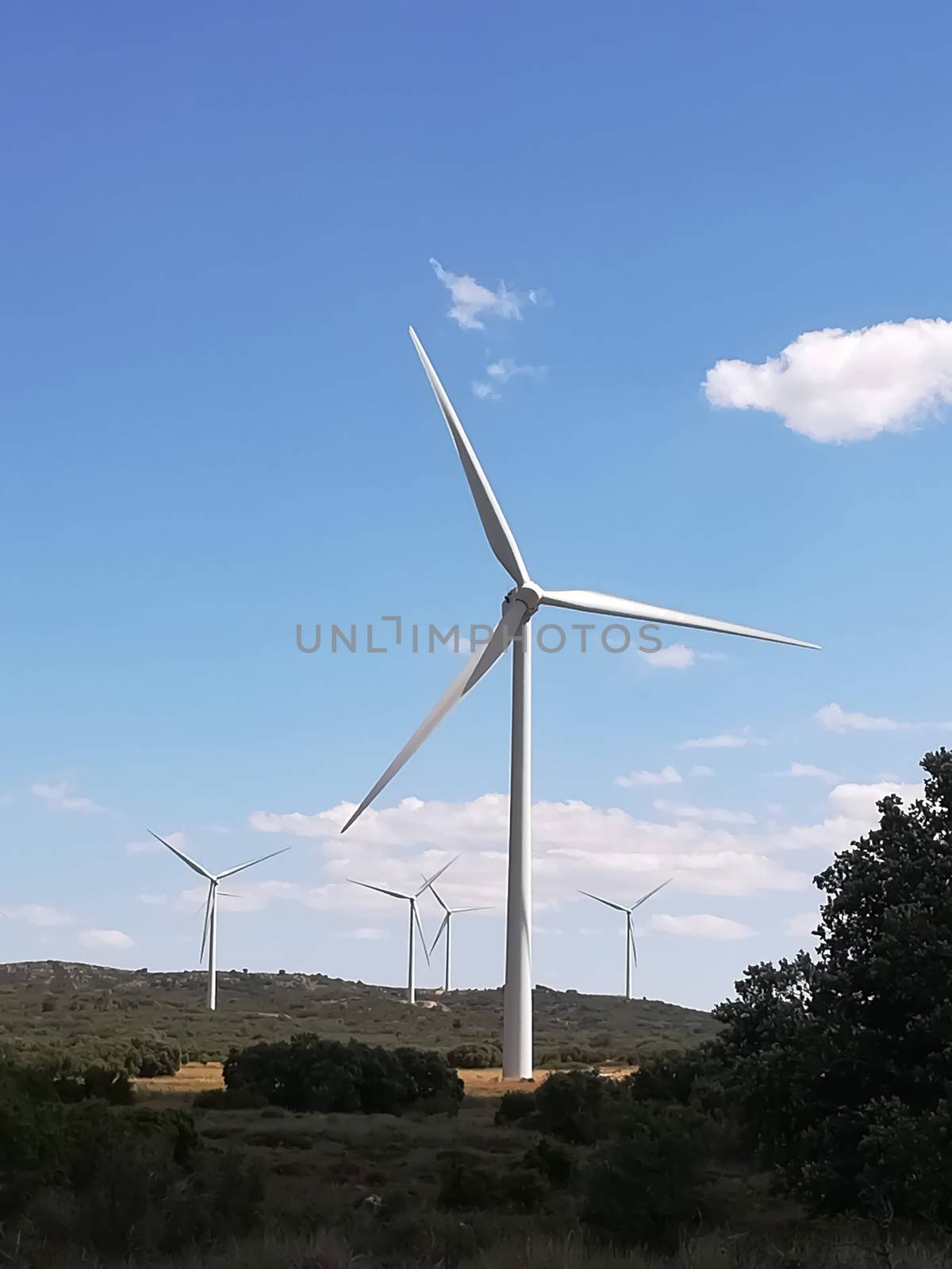 Wind generators on the mountain with blue sky in the background