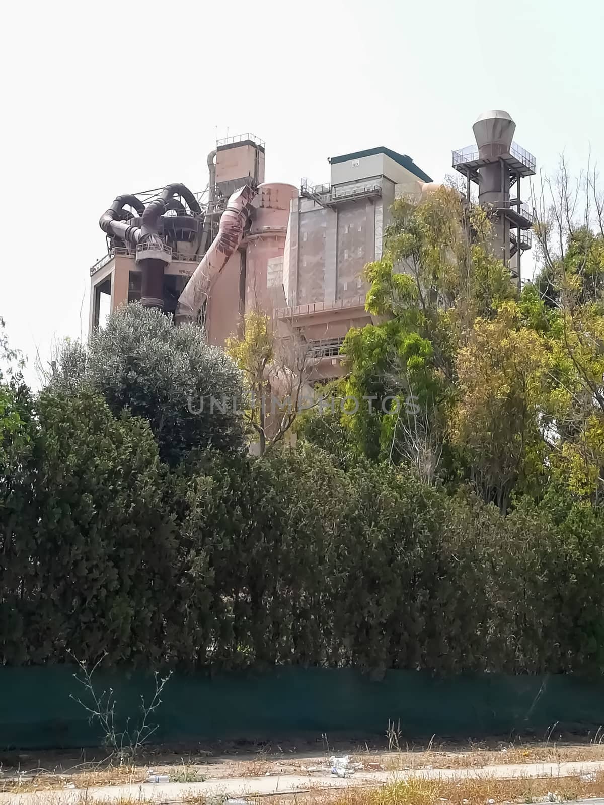 Old cement factory hidden behind very green trees