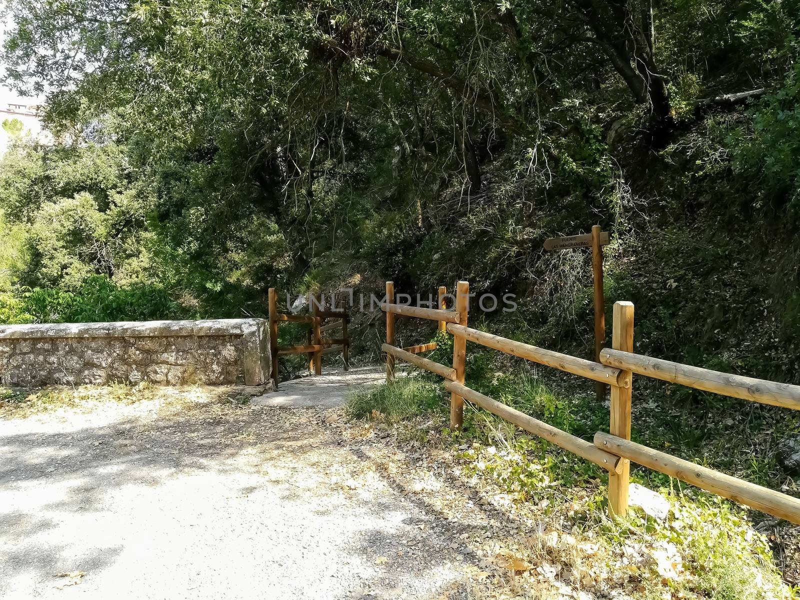Natural landscape with round wooden fences and a stone wall