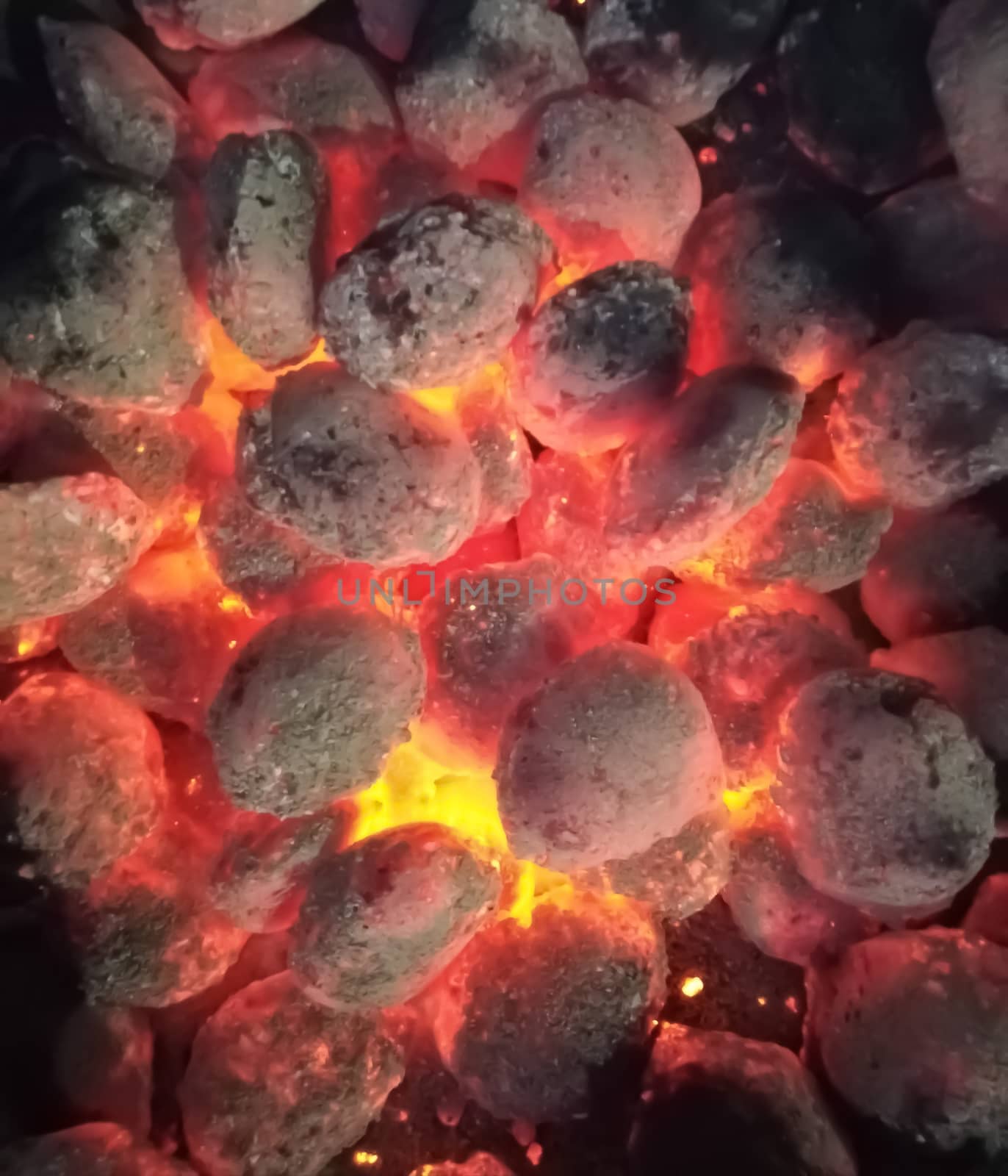 Incandescent coals in reddish, orange and yellow tones