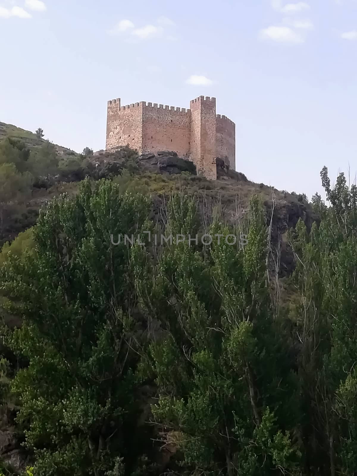 View of the ancient castle of Gaibiel with the forest below and the cloudy sky