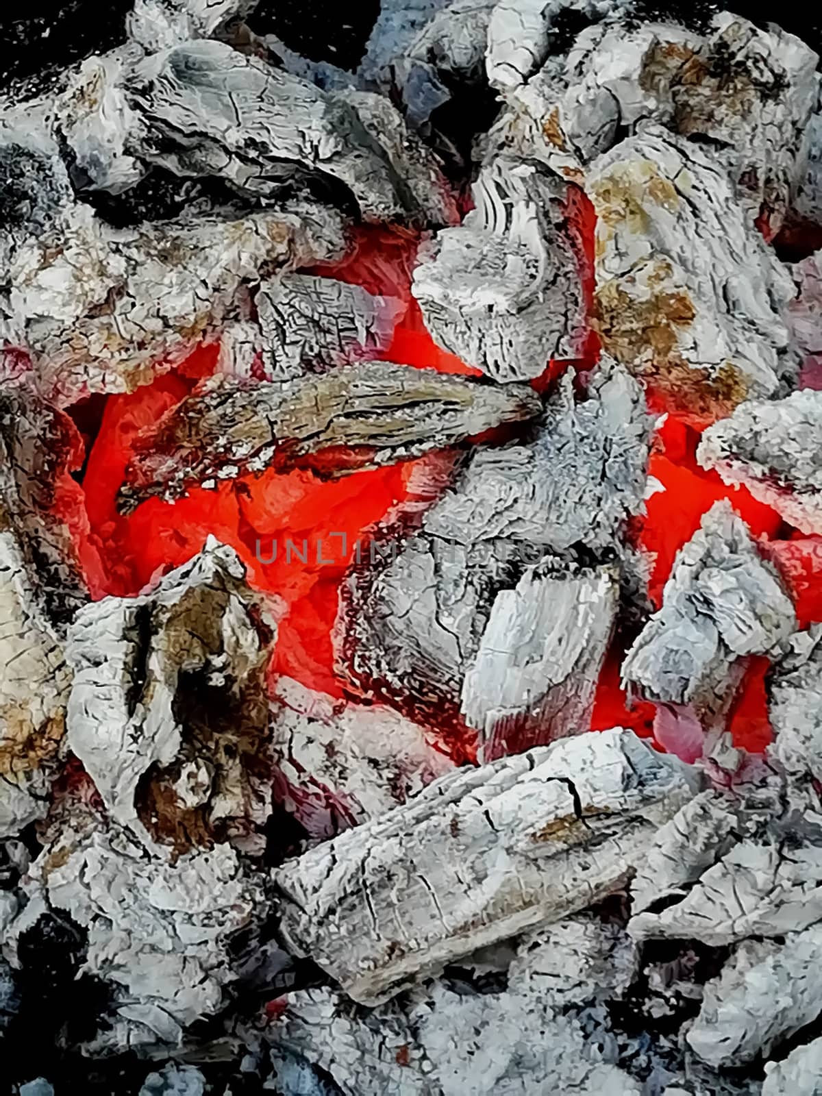 Incandescent coals in reddish, orange and yellow tones