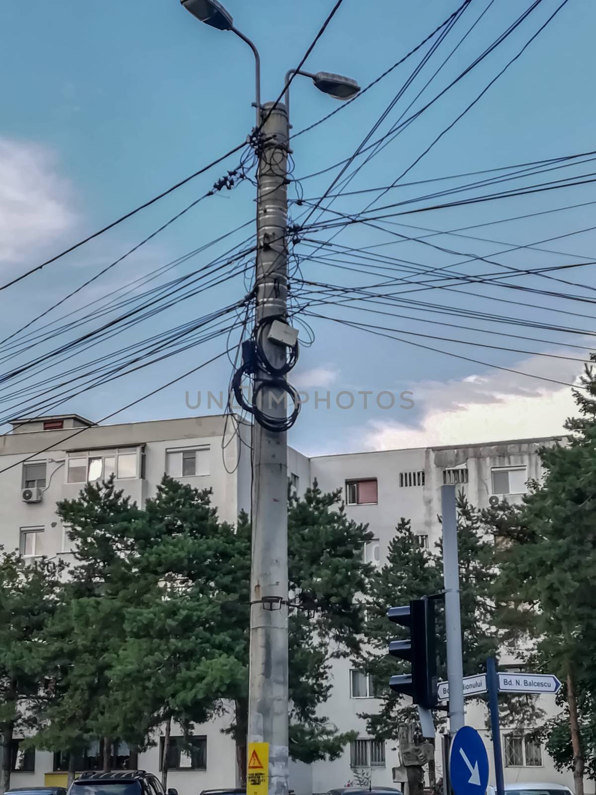 Pole of a light with many disorganized coiled cables in Buzau