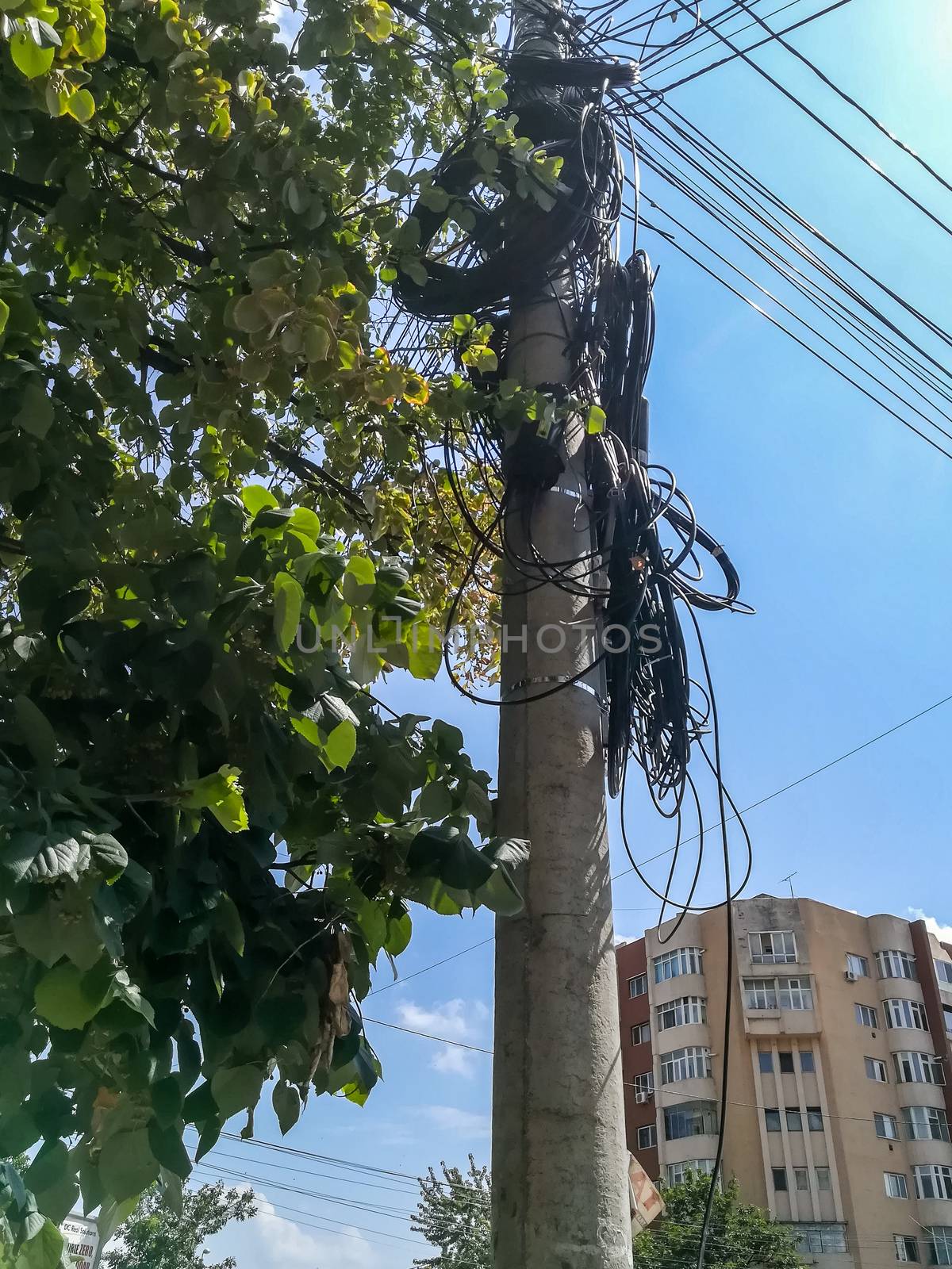 Pole of a light with many disorganized coiled cables in Buzau