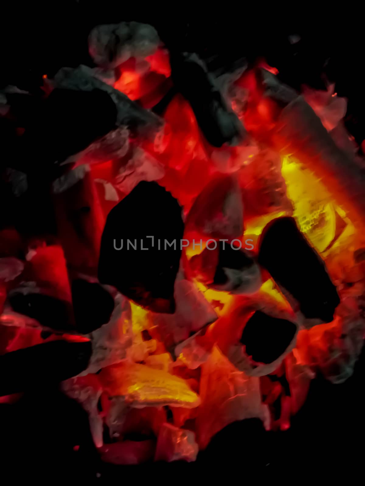 Incandescent coals in reddish, orange and yellow tones