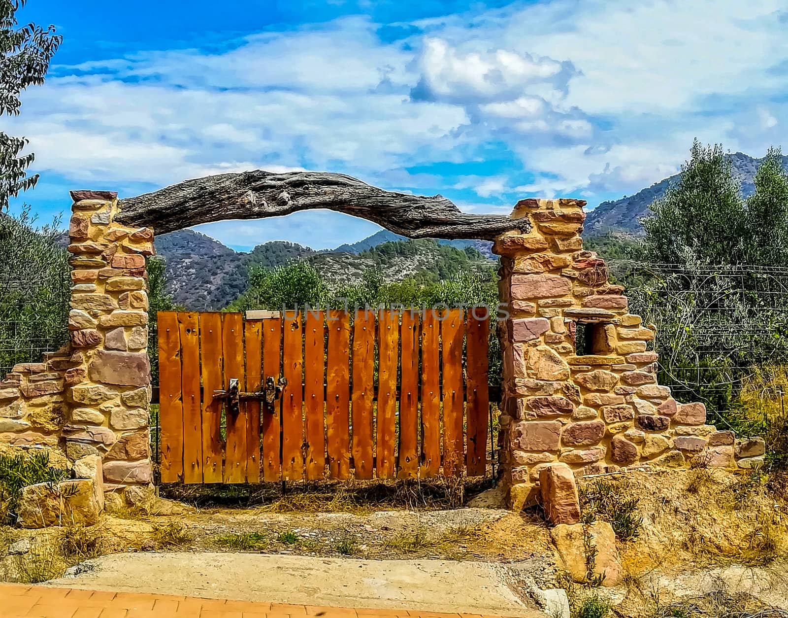 Nice rural stone door with a crossbar trunk and the mountains in the background