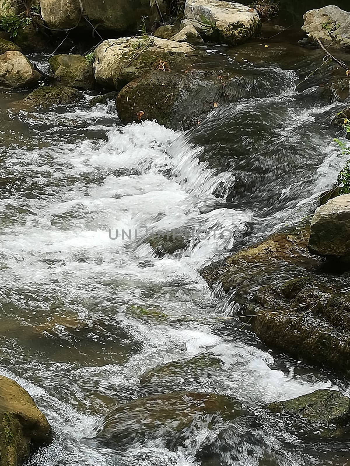 Rocks forming a small dam in the Palancia river as it passes through Segorbe