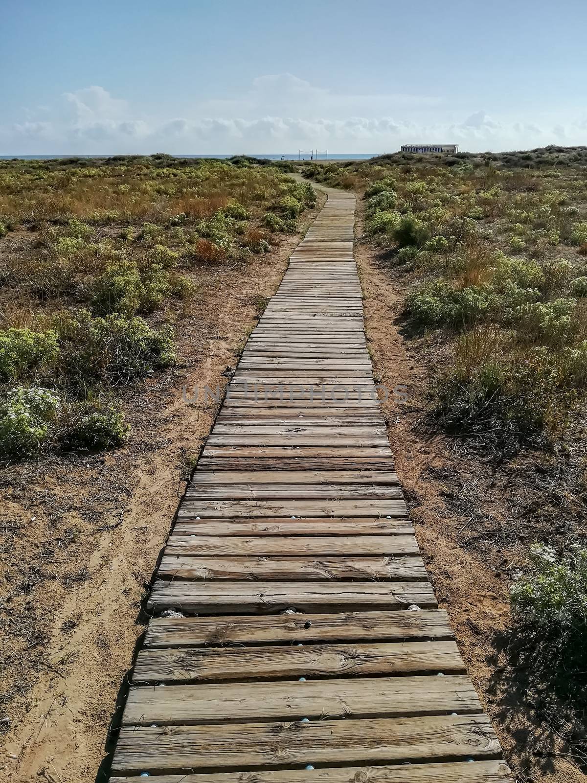 Wooden walkway to access the beach with the Mediterranean Sea in the background