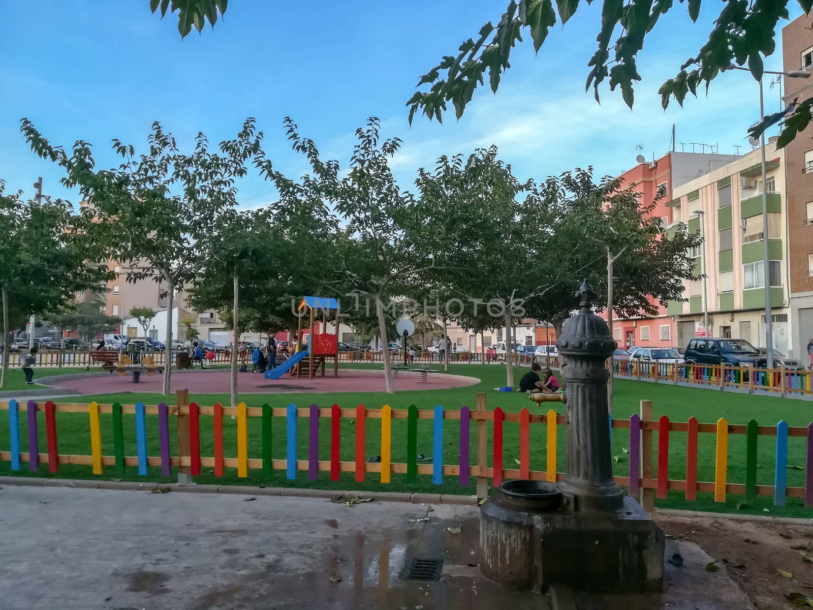 children playground with very colorful swings and some trees