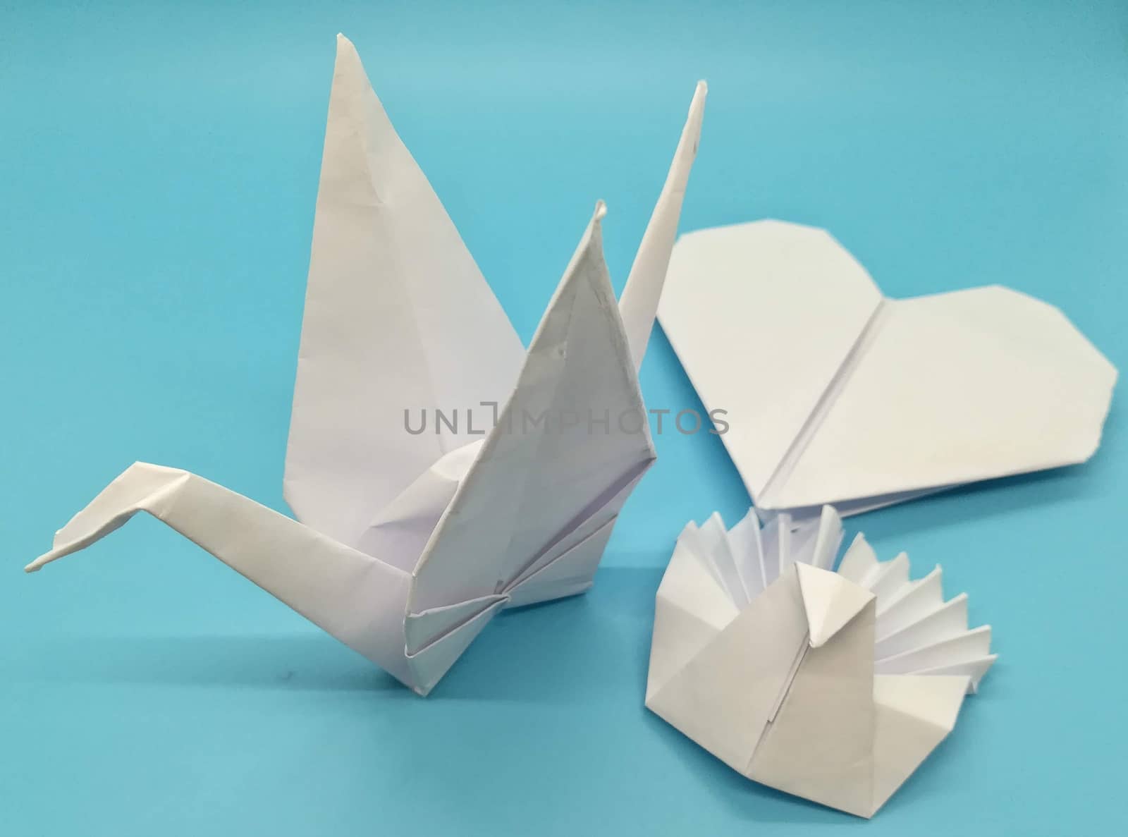 Origami figures made with white paper on blue background