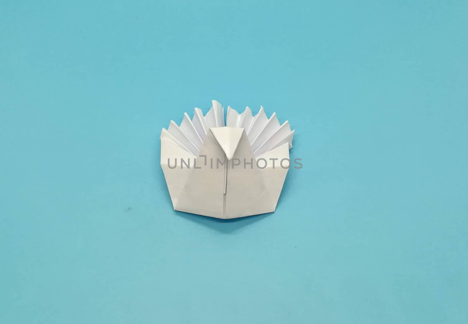 Origami figures made with white paper on blue background