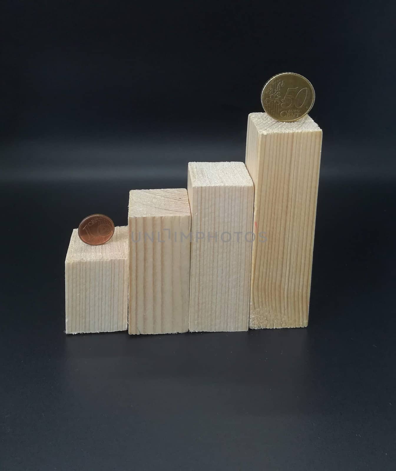 Wooden blocks on staircase with coins on black background