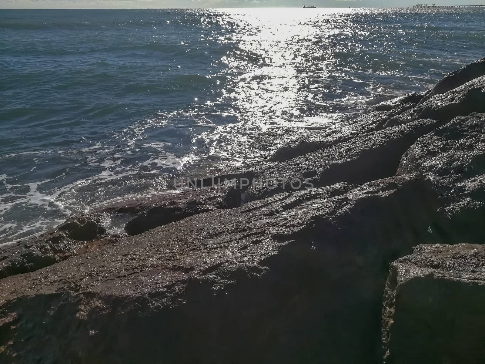 View of the Mediterranean sea breaking against the rocks generating sea foam