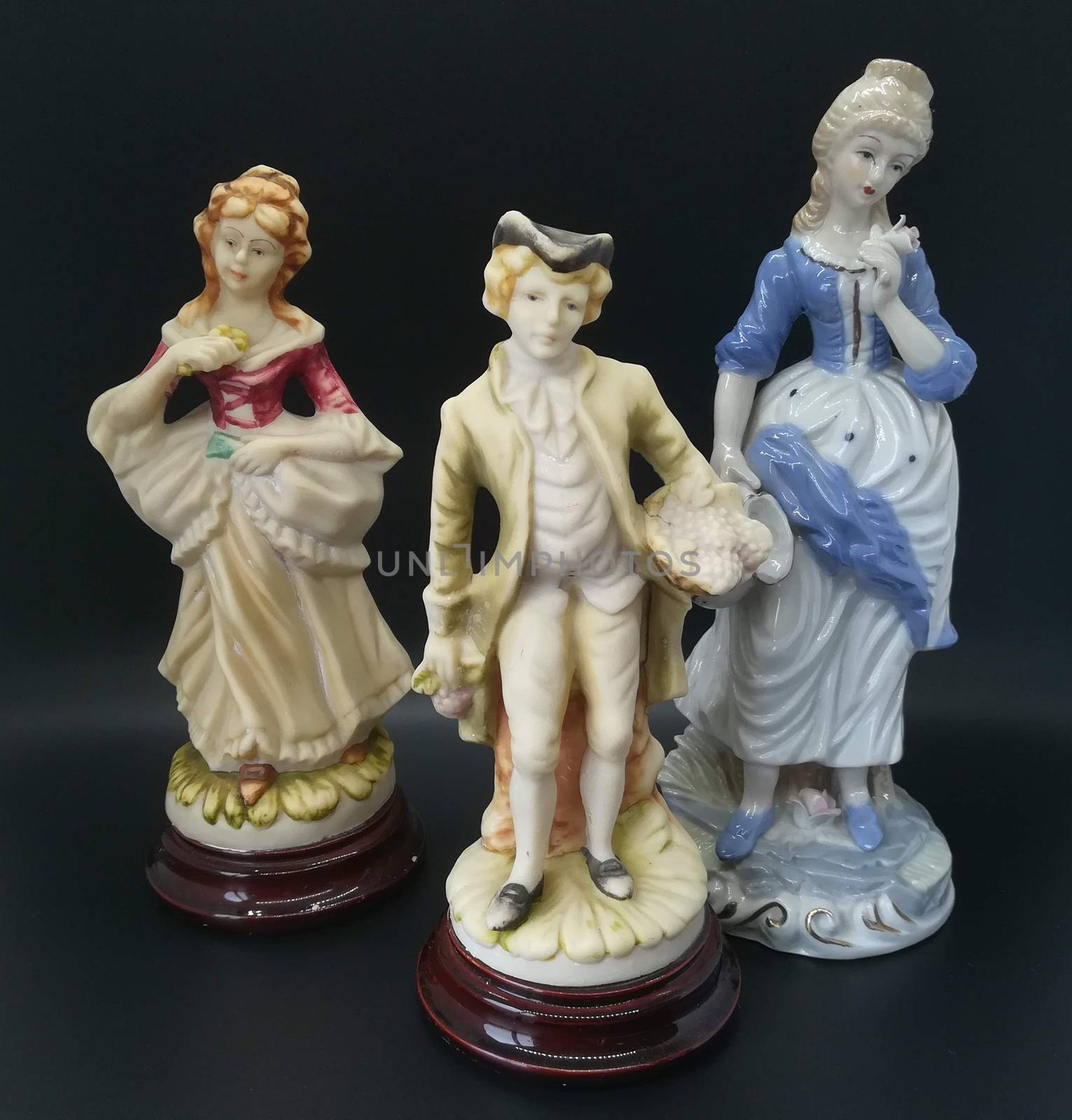 Ceramic figures of people on black background