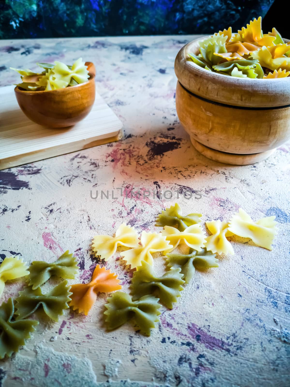 Colorful pasta ties in composition on light and rough background