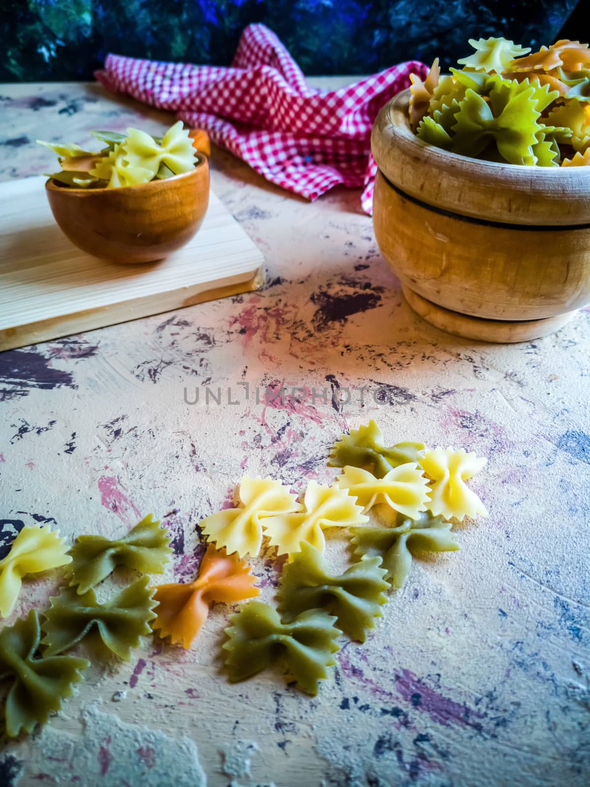 Colorful pasta ties in composition on light and rough background