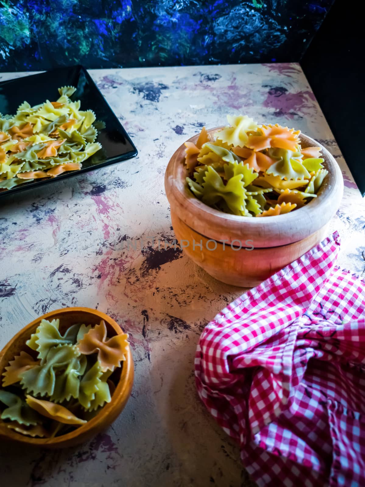 Colorful pasta ties in composition on light and rough background