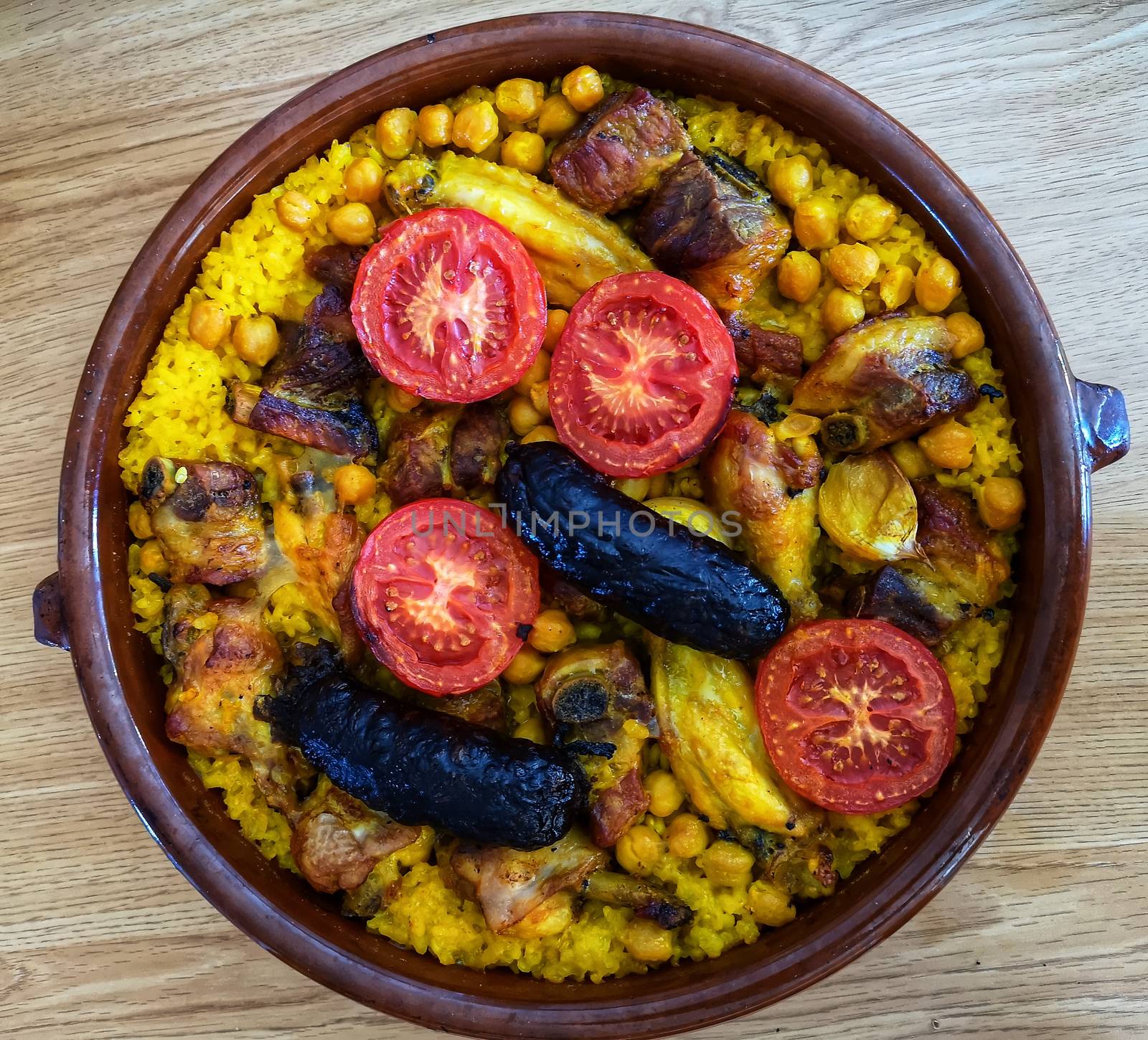 Typical spanish food with rice meat, tomato and blood sausage