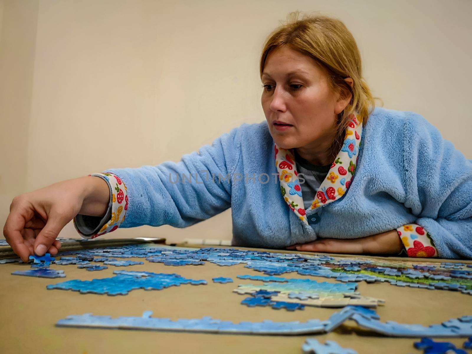 Woman in lab coat making puzzle at home