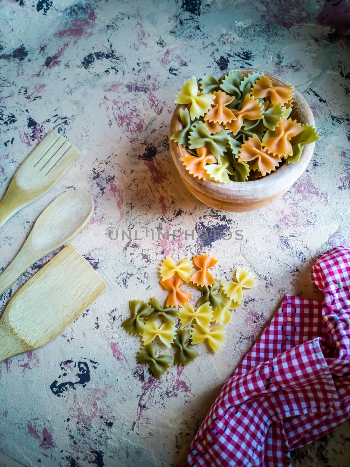 Colorful pasta ties in composition on light and rough background
