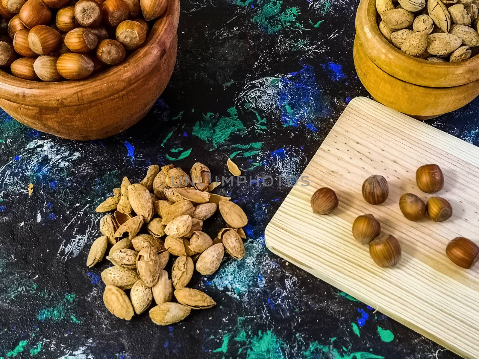 Walnuts and hazelnuts in composition on dark and rough background