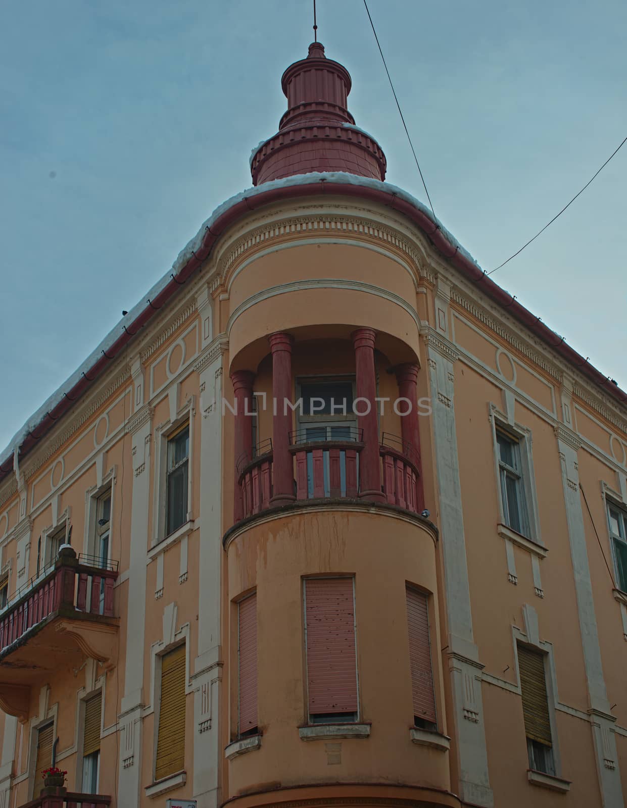 Top corner of an old style building with an orange facade