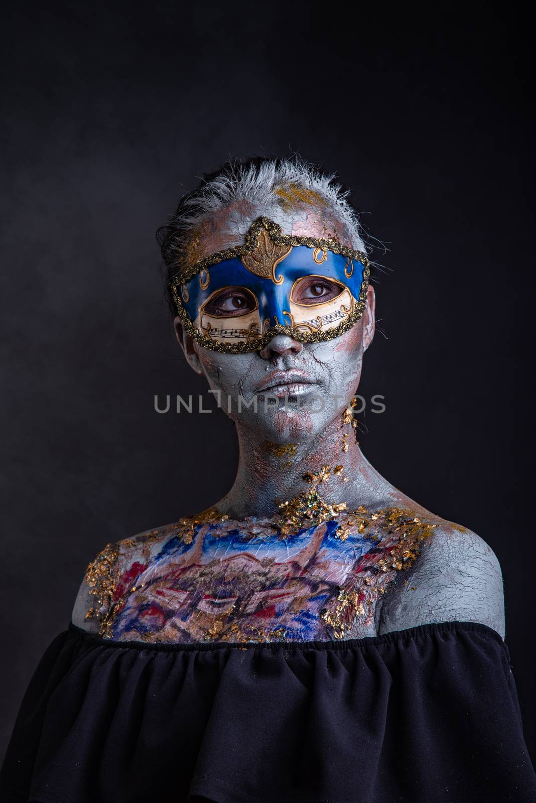 Portrait of a young masked woman with creative makeup on the theme of Venice Carnival