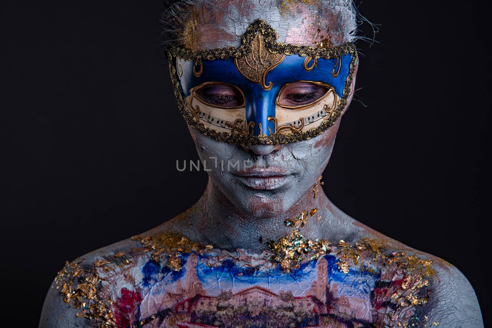 Portrait of a young masked woman with creative makeup on the theme of Venice Carnival