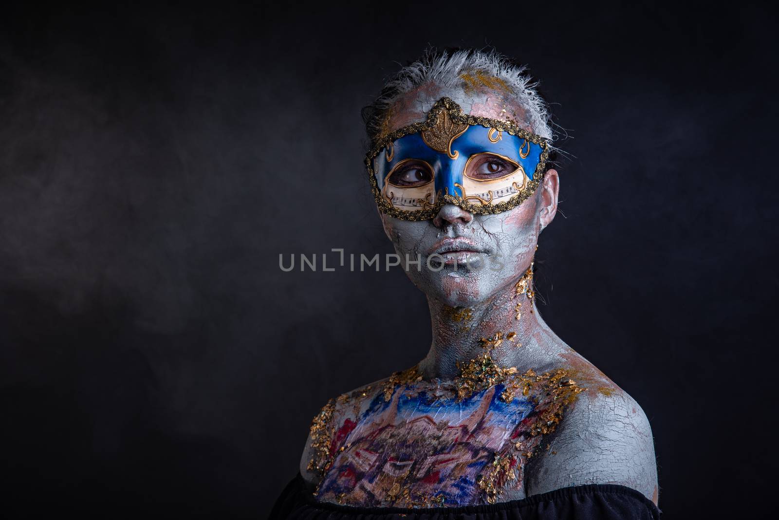 Portrait of a young masked woman with creative makeup on the theme of Venice Carnival