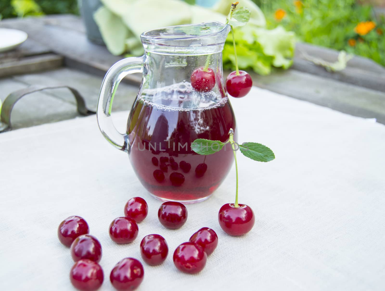 Cold cherry juice in jar and ripe berries, selective focus.