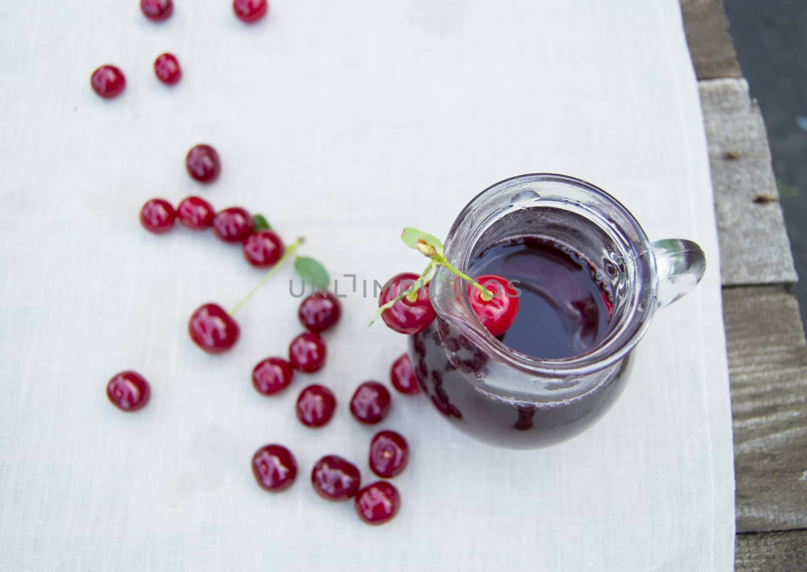 Cold cherry juice in jar and ripe berries, selective focus by claire_lucia